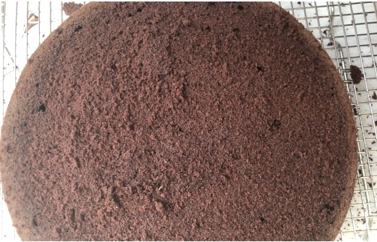 Baked chocolate mayonnaise cake layer cooling on a wire rack.
