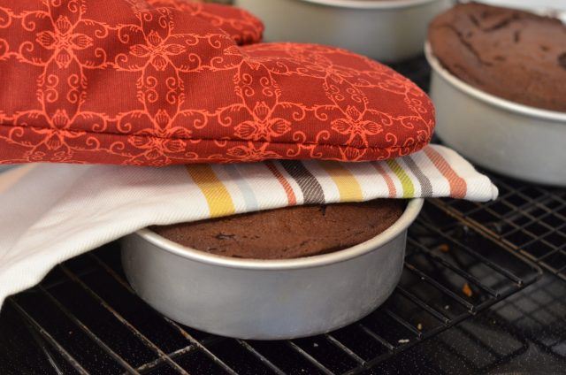 If chocolate cake is domed up place tea towel on top and gently push down with oven mitt