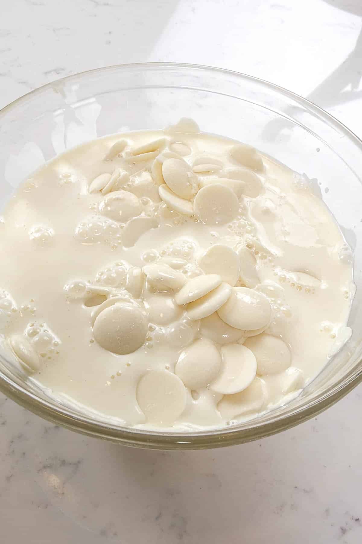 Clear bowl with chocolate and cream inside.