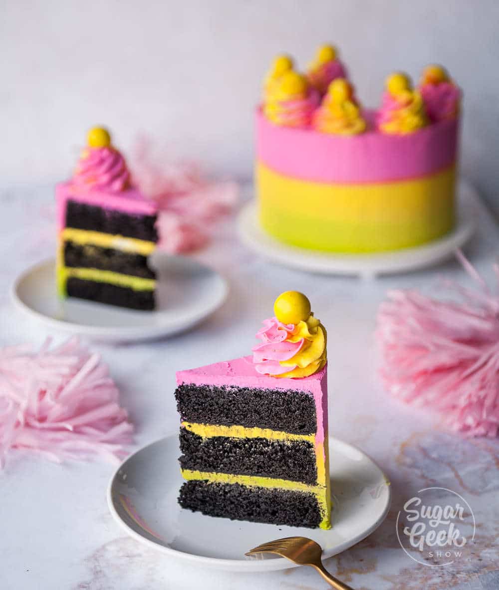 two slices of black velvet cake on a white plate with cake in the background