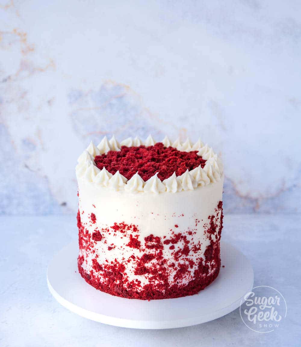 red velvet cake with crumbs and buttercream dollops
