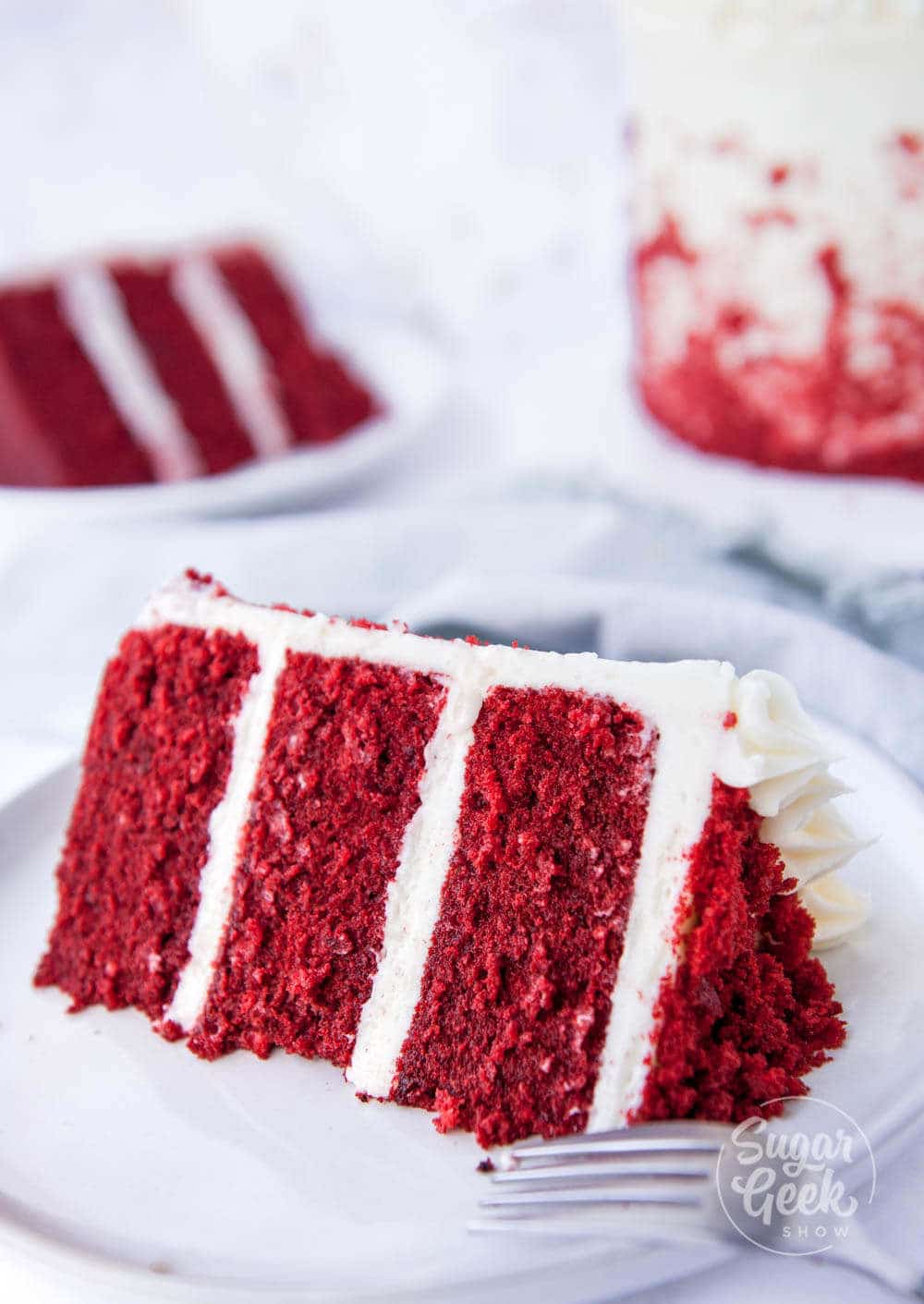 classic red velvet cake with cream cheese frosting on white plate