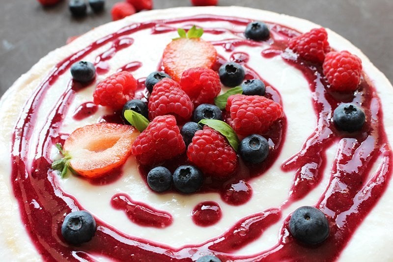 aardbeienpuree op cheesecake met verse bessen