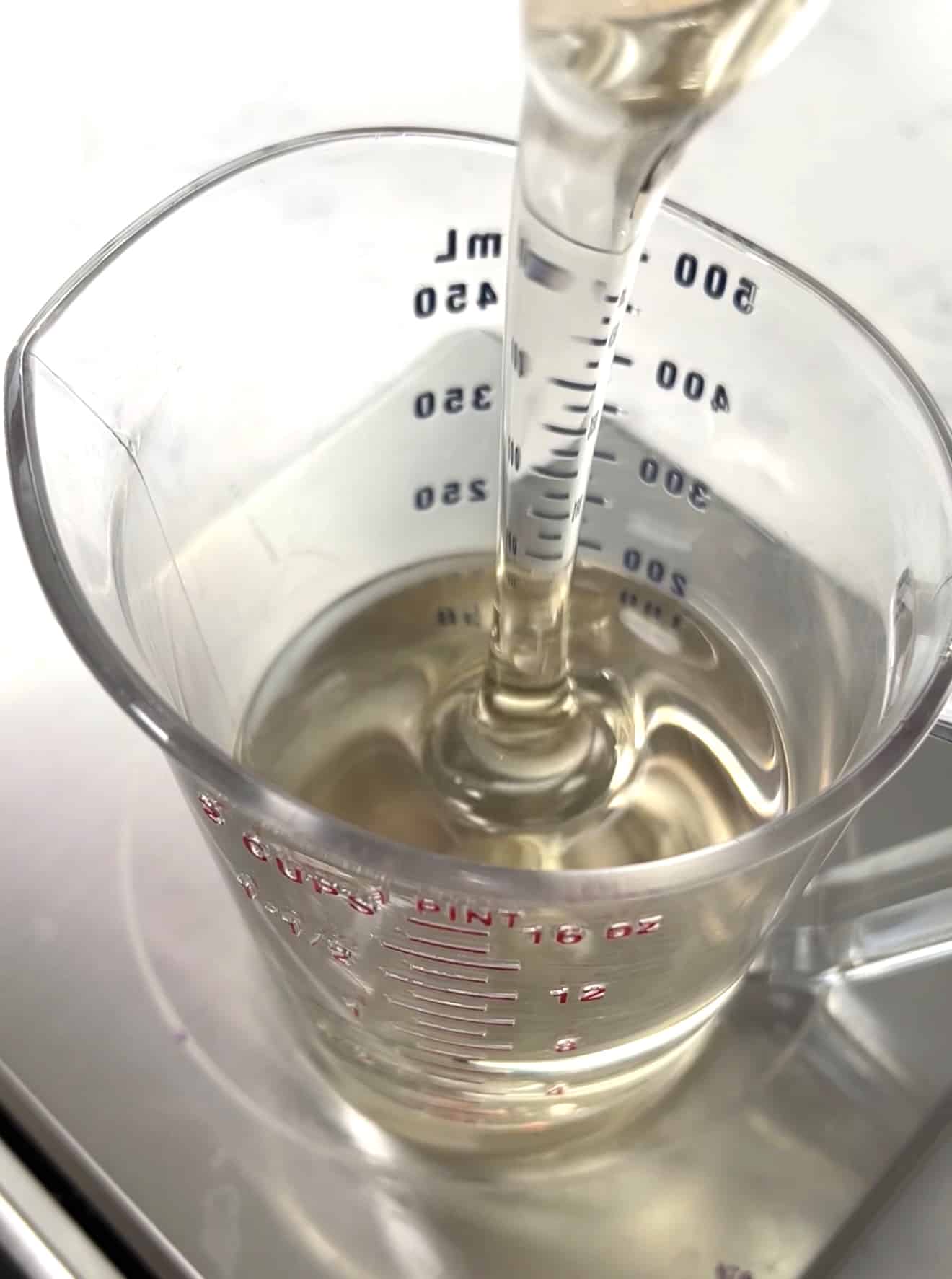 Close up of corn syrup being poured into a measuring cup