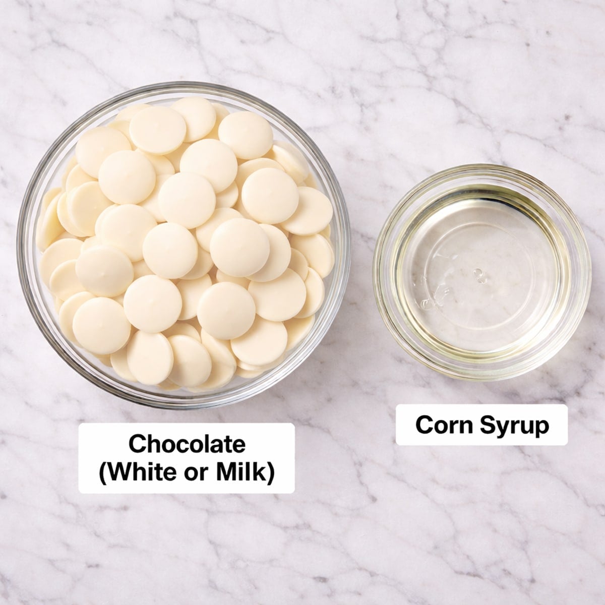 Modeling chocolate ingredients in bowls on a white countertop.