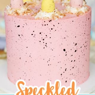 pink speckled easter cake with coconut nests and candy eggs on top