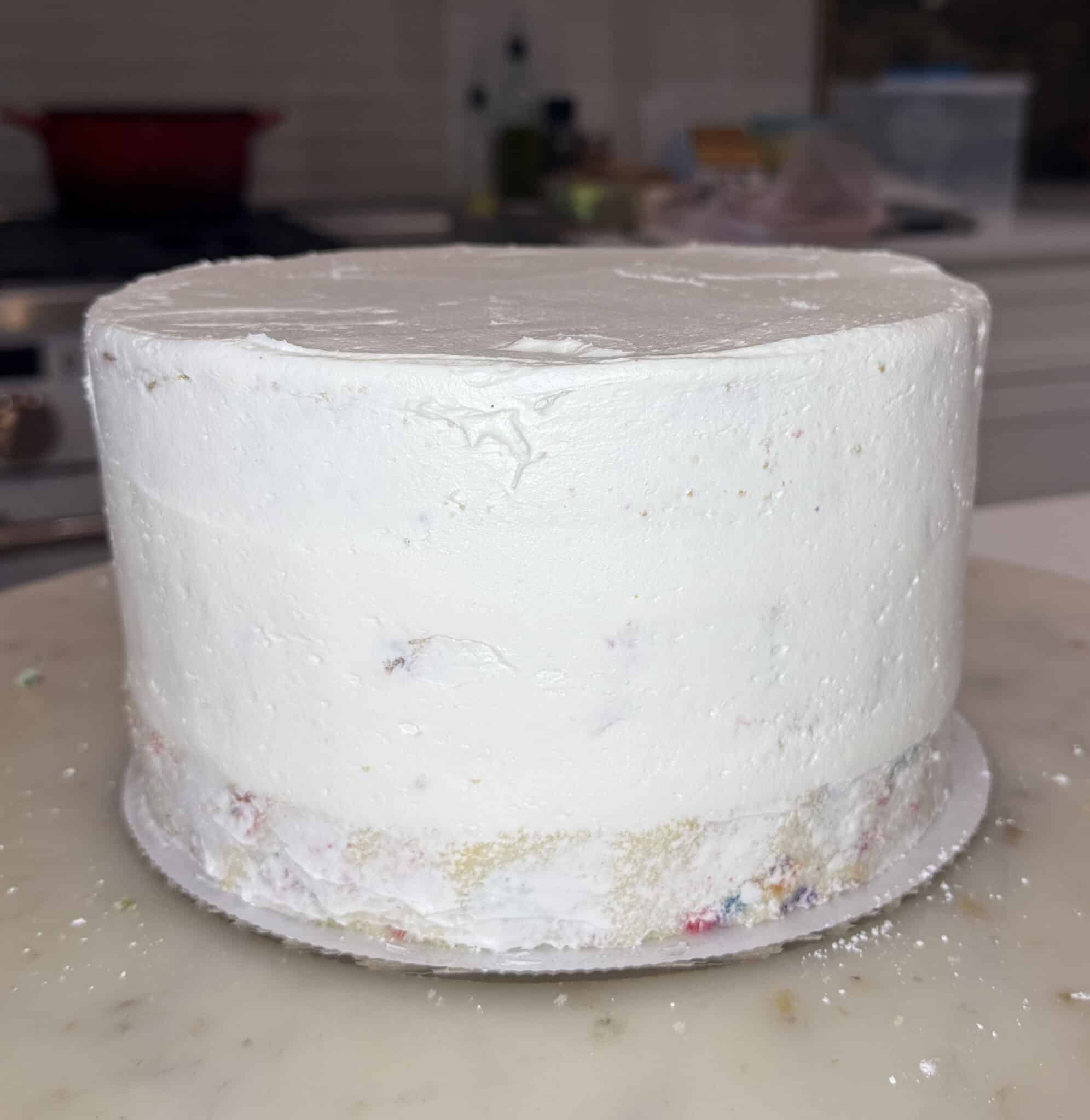 Applying a crumb coat to a layer cake