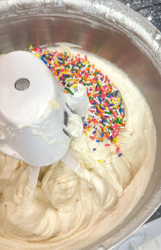 closeup of funfetti cake batter and sprinkles in a mixing bowl