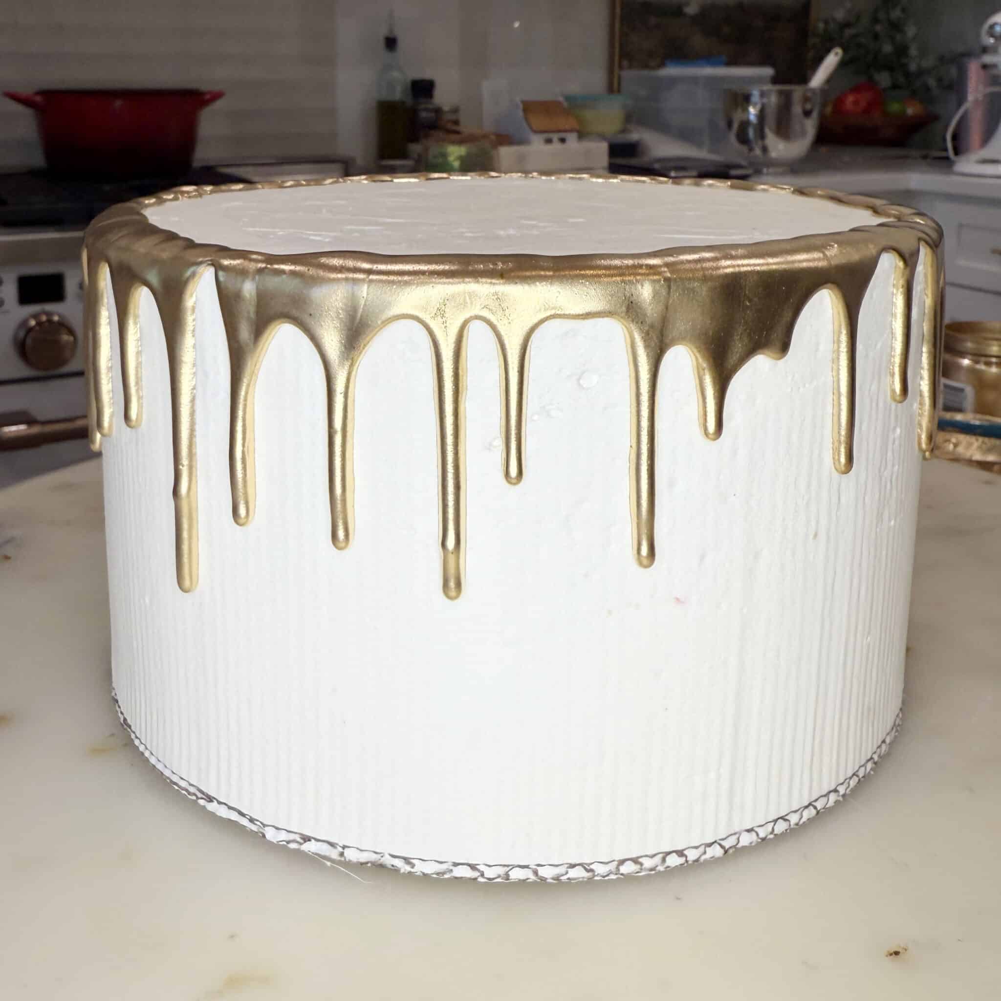 gold piped drip on a white cake