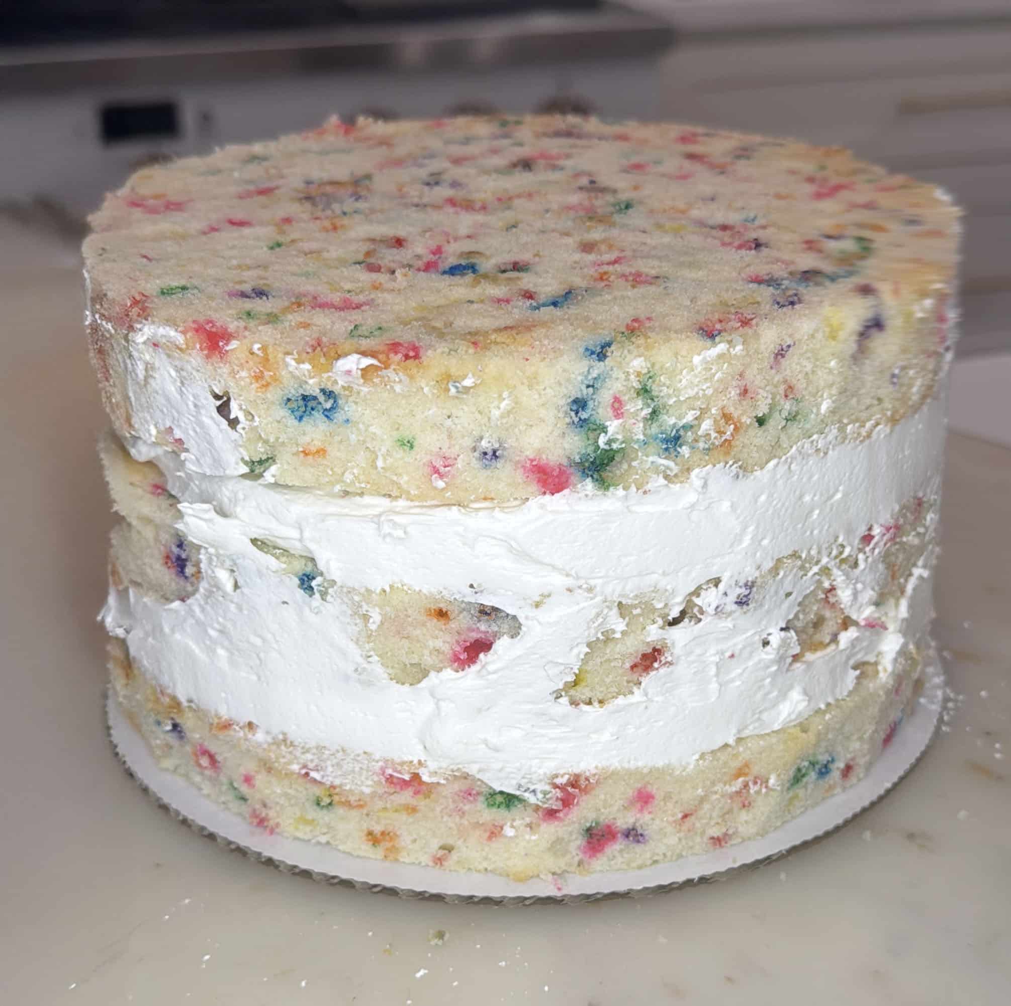 close up of stacked funfetti cake layers with buttercream frosting