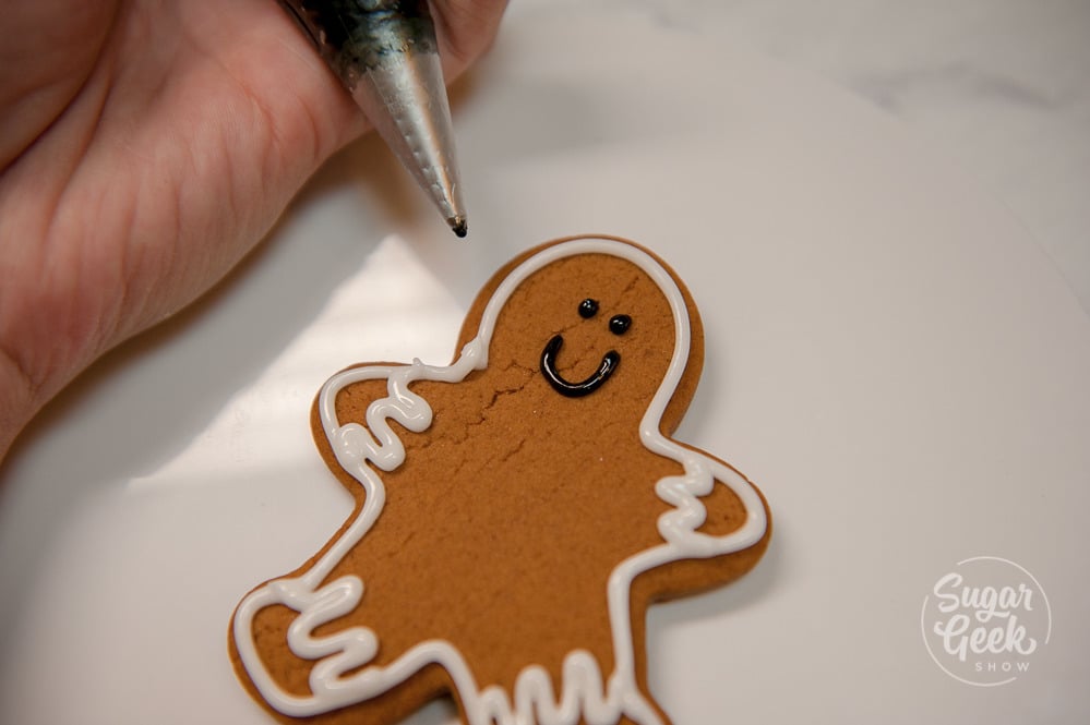 Pipe a face onto your gingerbread cookie with black royal icing