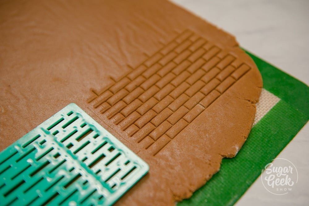 Chilled gingerbread dough with a brick pattern pressed into it to give texture. 