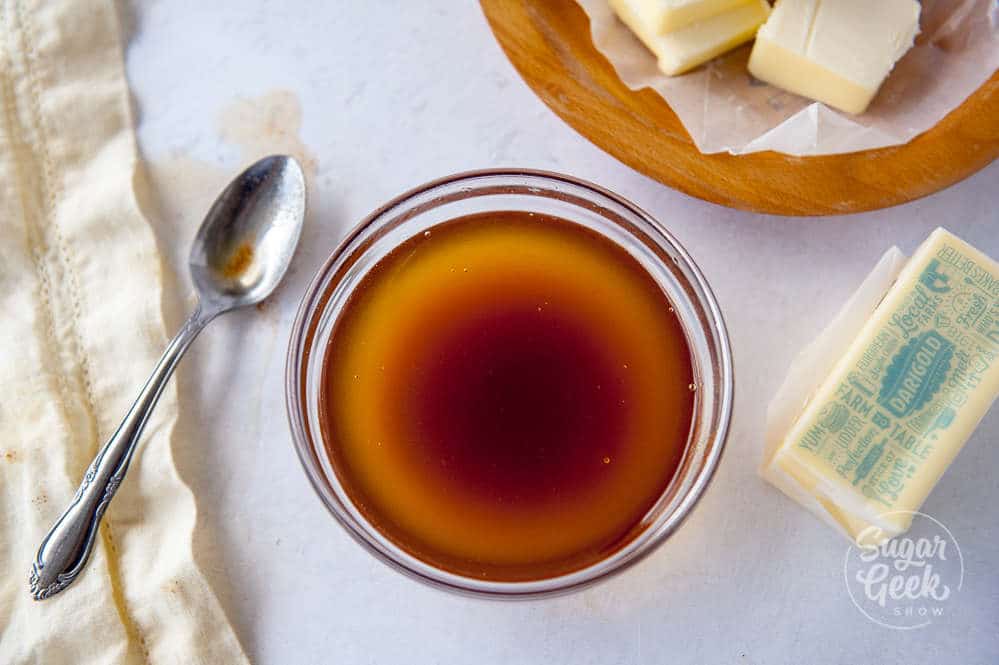 brown butter in a heat proof bowl surrounded by butter and a spoon