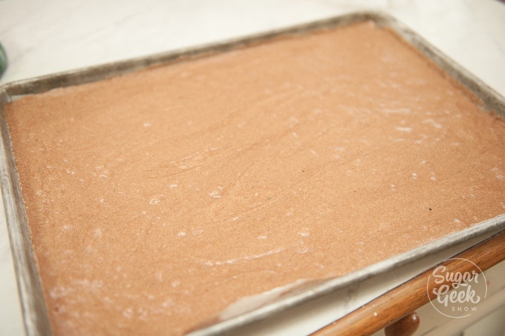 spread chocolate joconde batter onto a baking sheet