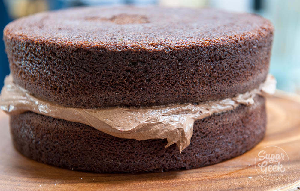 Frosting between two layers of chocolate cake