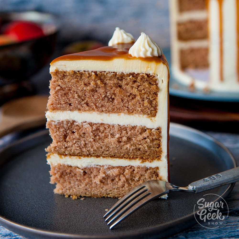 slice of applesauce cake with cream cheese frosting on black plate