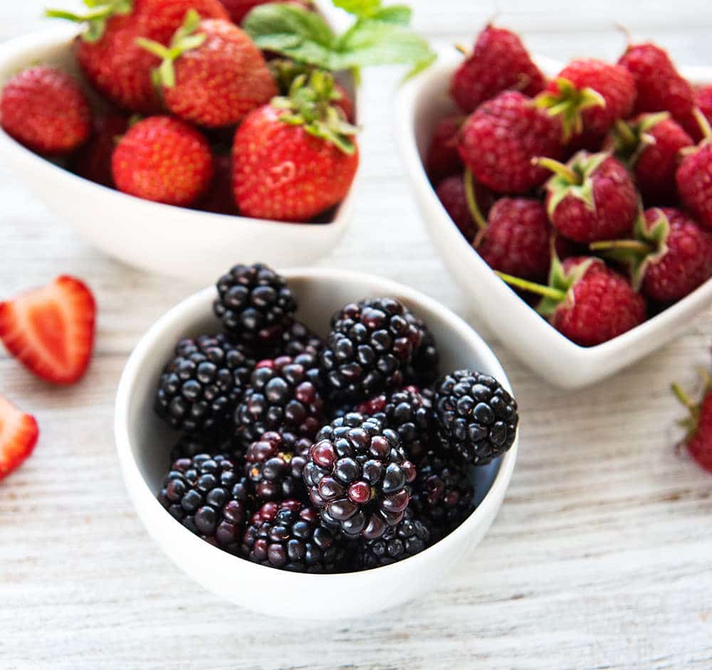 mixed berries in white bowls