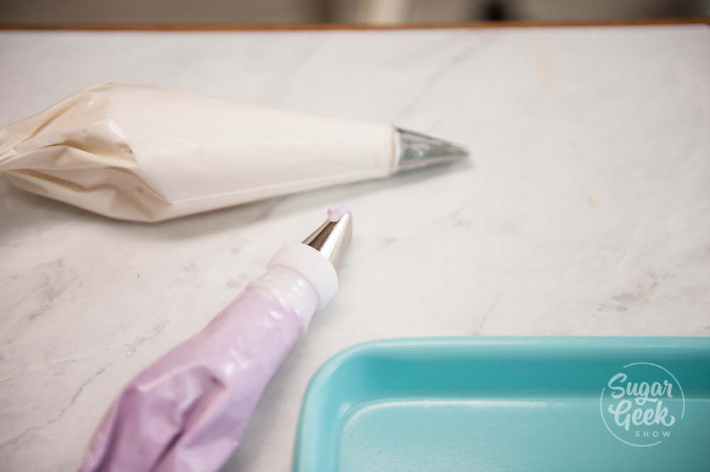 Piping bags with piping tips on a white countertop.
