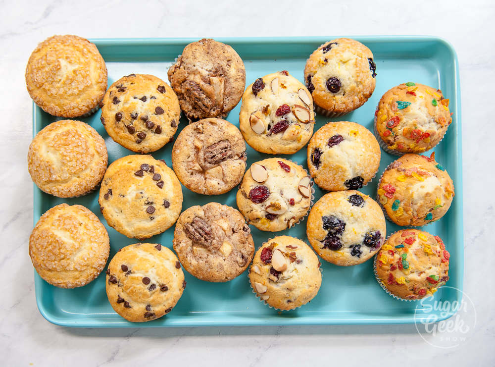 different muffin combinations made from the same basic muffin recipe on a blue cookie sheet