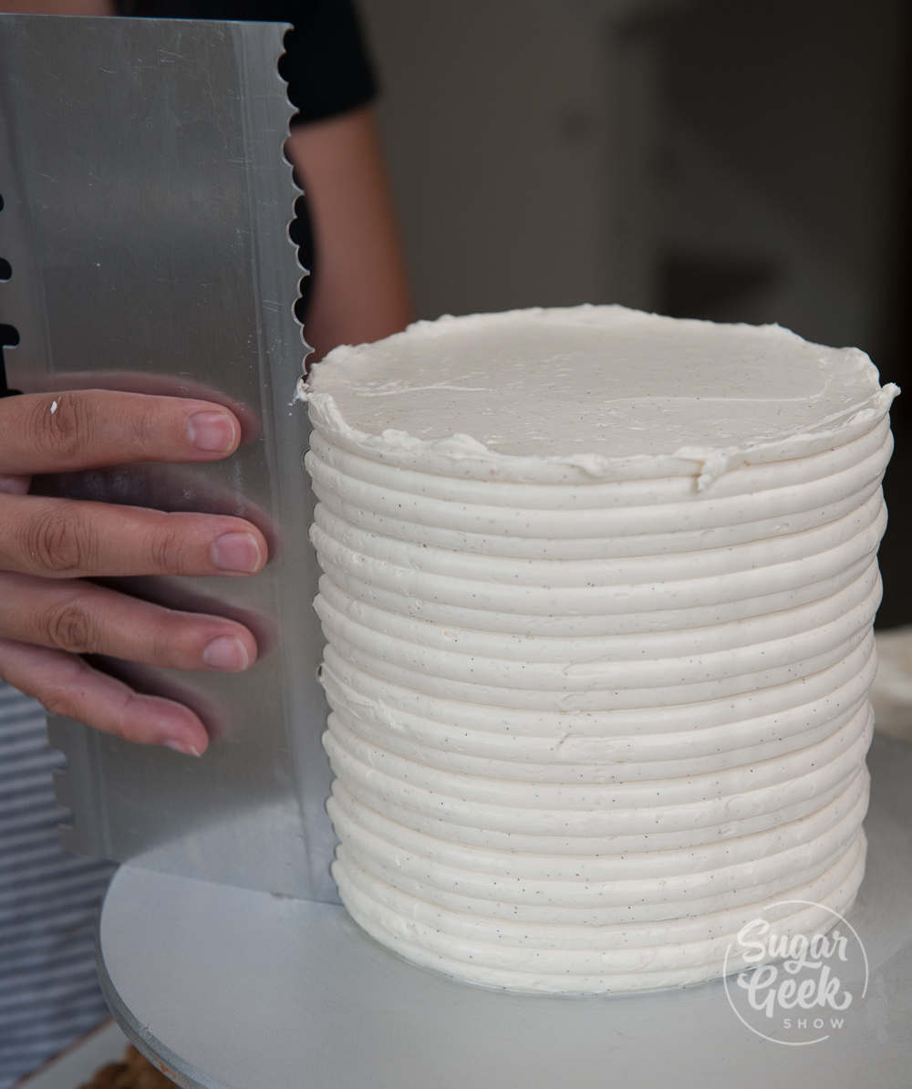 Using an ester cakes cake comb to put lines in the buttercream