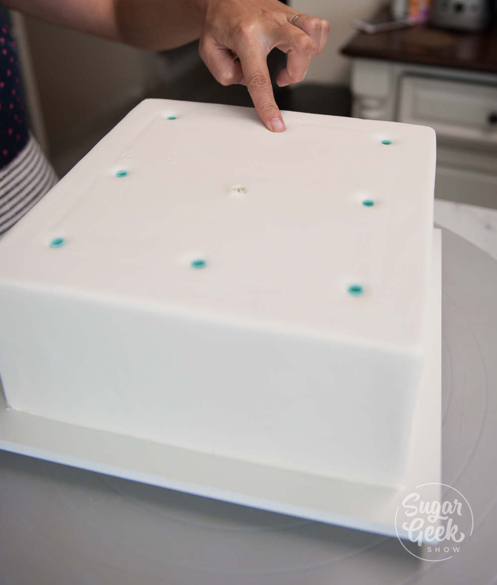 inserting straws into the cake