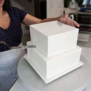 assembling the chilled wedding cake tiers using an offset spatula