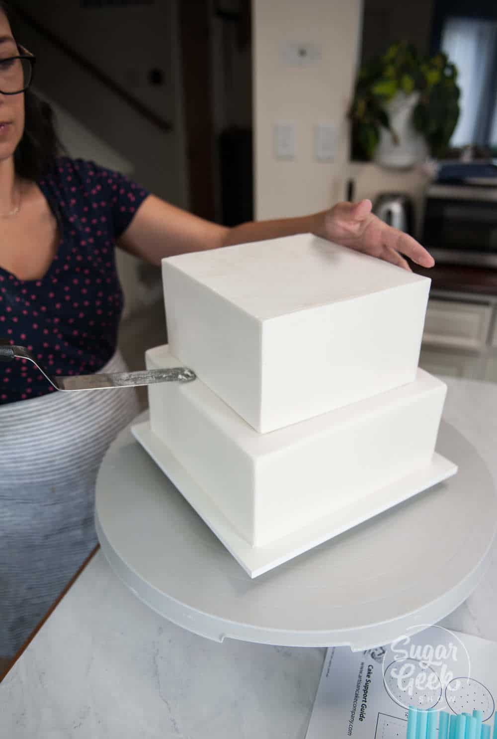 assembling the chilled wedding cake tiers using an offset spatula