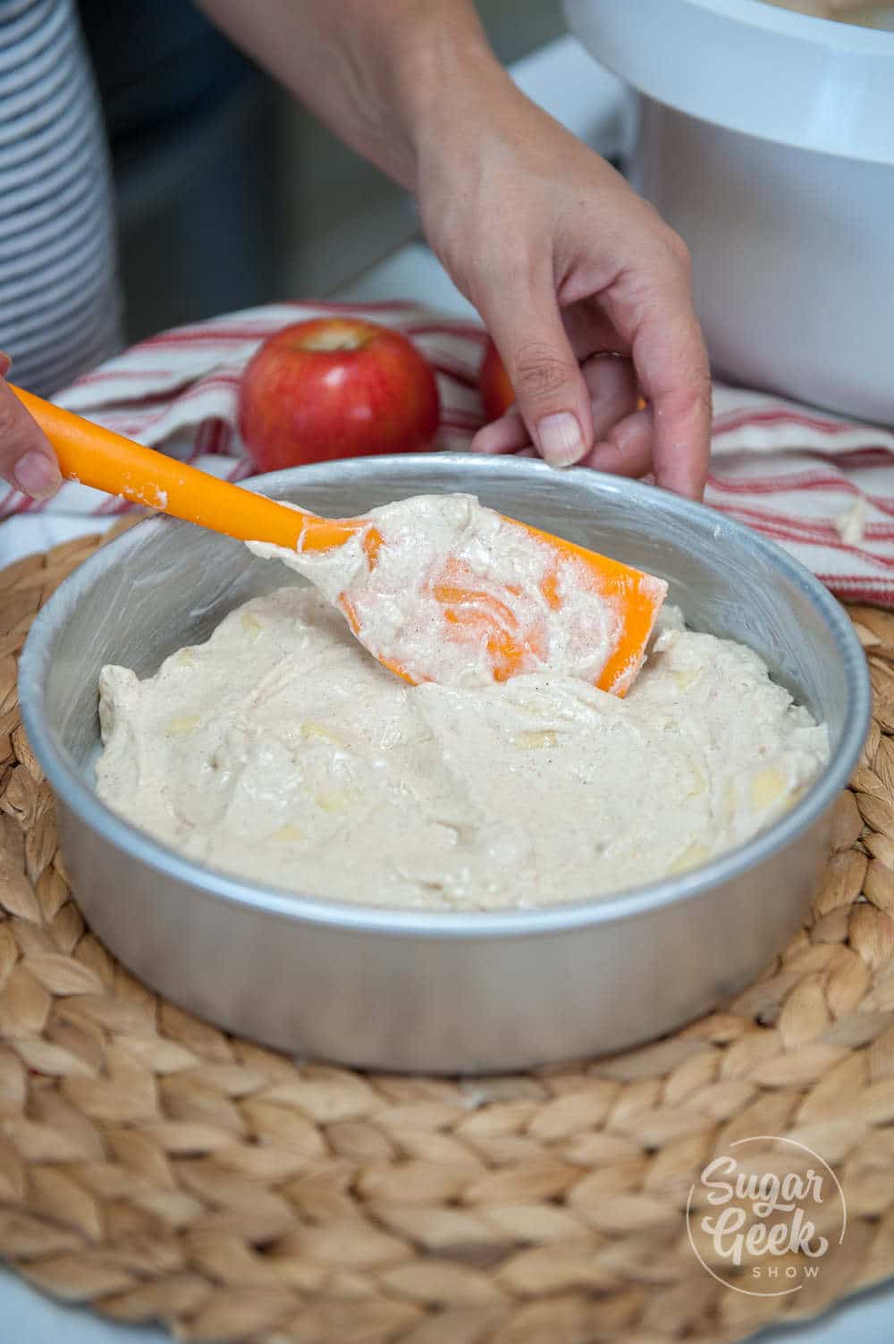 Fresh Apple Cake batter being spread in a cake pan with a rubber spatula.