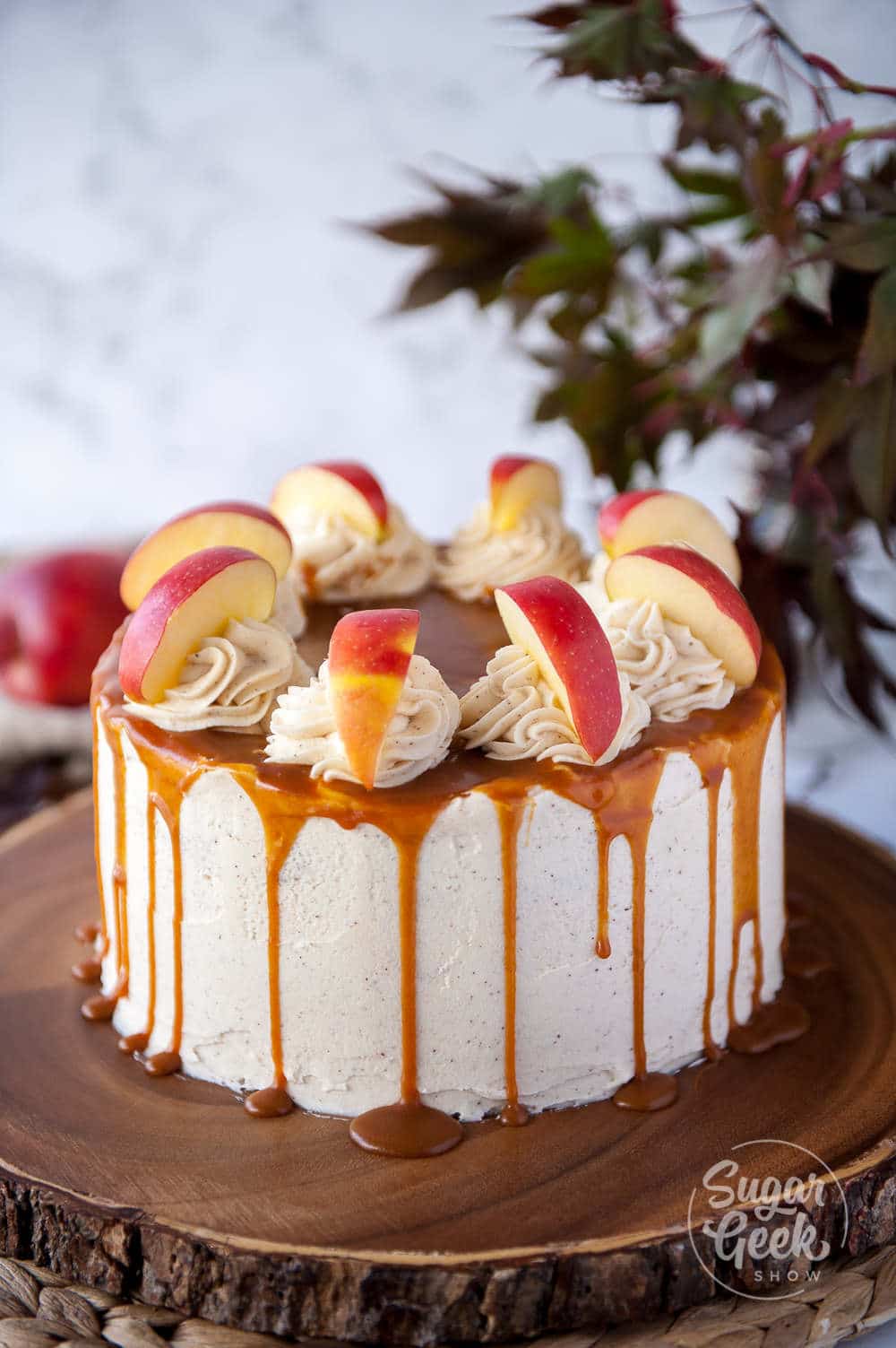 Frosted and decorated Fresh Apple Cake with caramel drizzle.