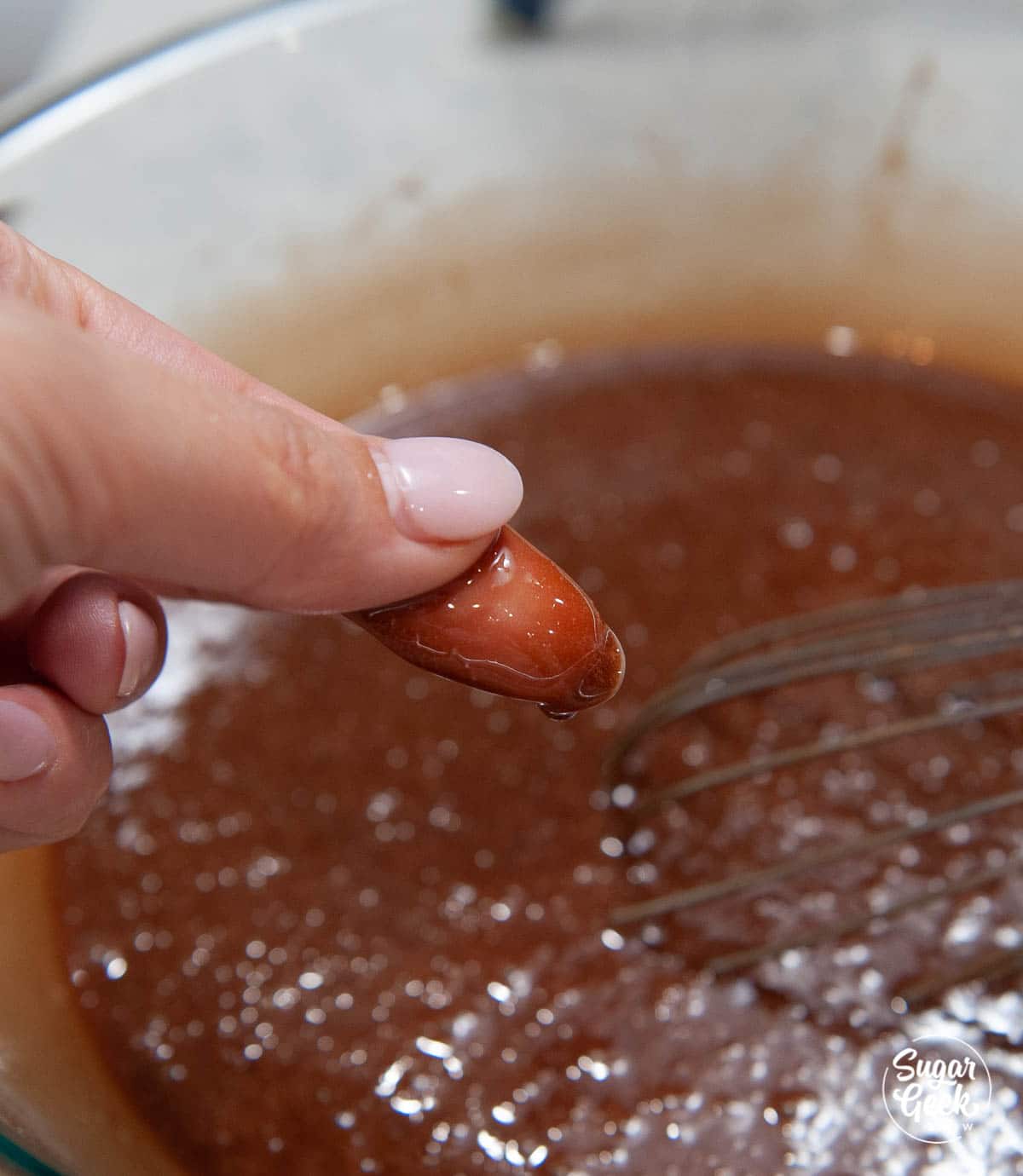 close up of fingers touching brownie batter