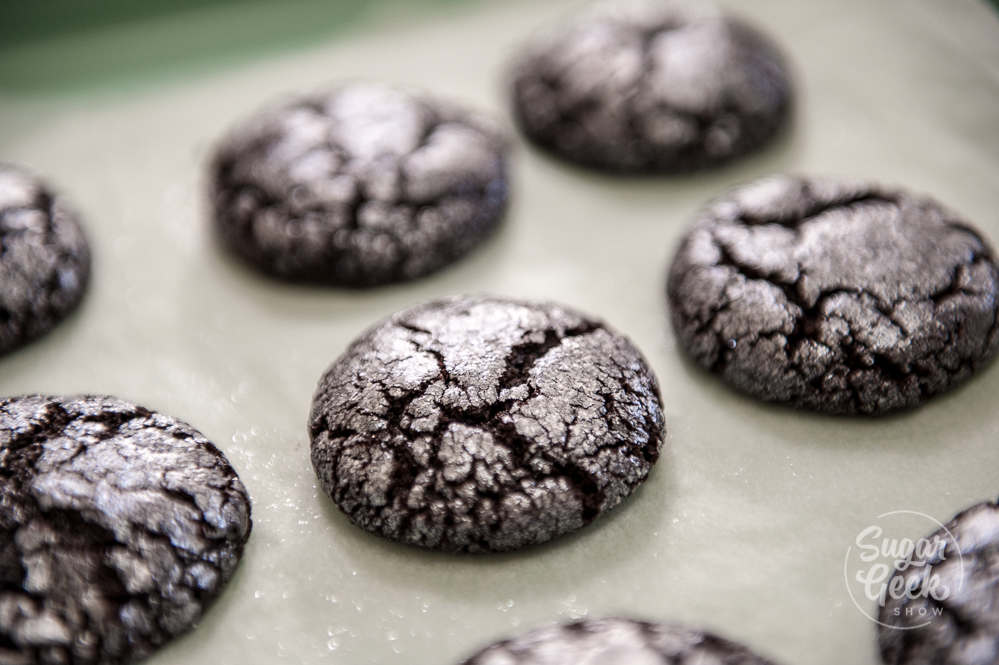 glitter chocolate crinkle cookies on a cookie sheet