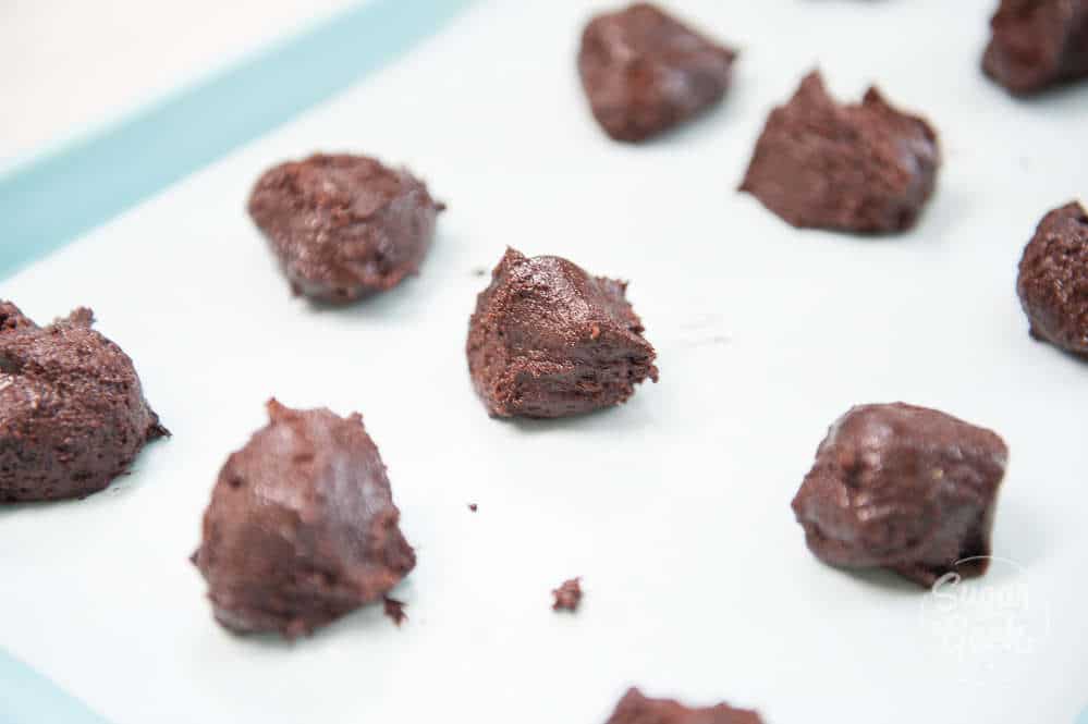 chocolate crinkle cookie dough on a parchment paper lined cookie sheet