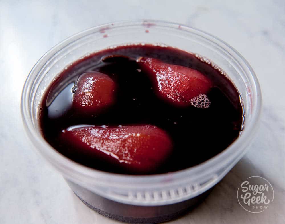 cooling poached pears in hot red wine poaching liquid to deepen the color