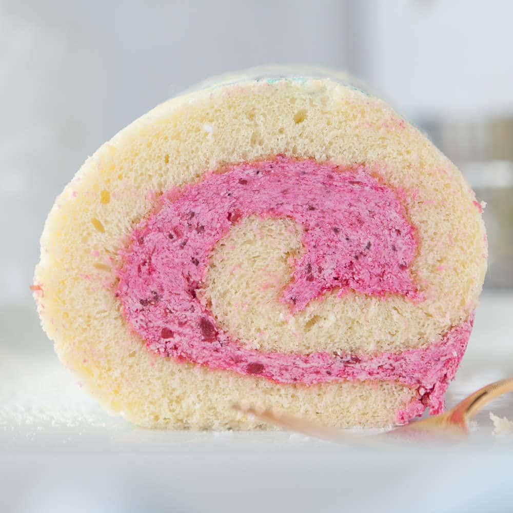 close up of vanilla roll cake with strawberry filling