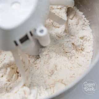 closeup of mealy pie dough in a mixer