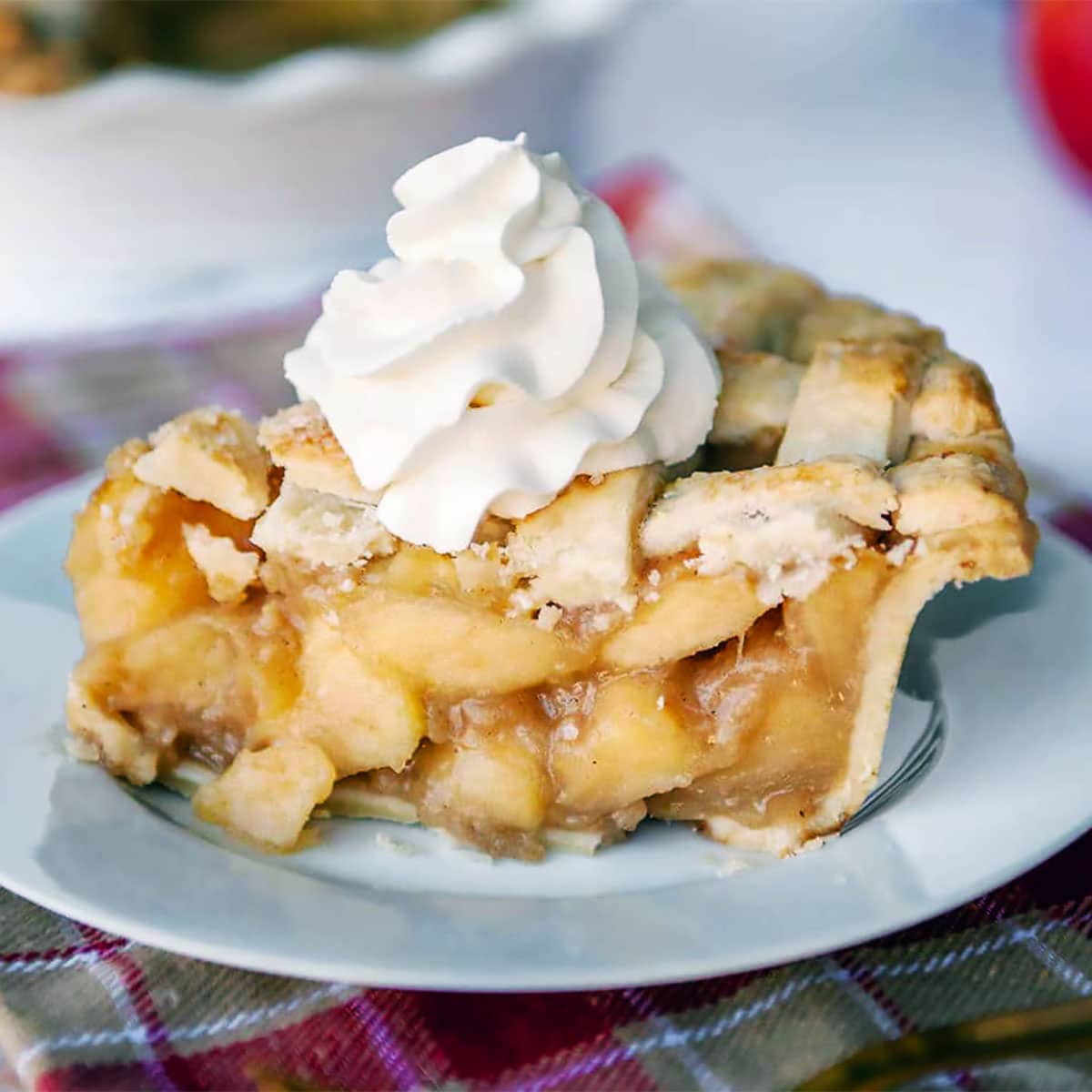 close up of a slice of caramel apple pie on a white plate