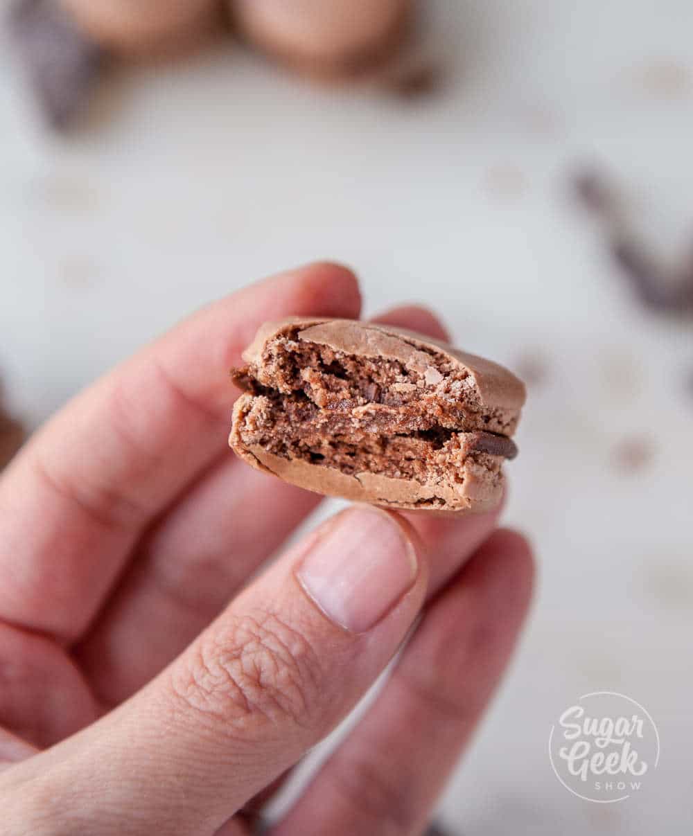 chocolate macaron with bite taken out of it to show the inside