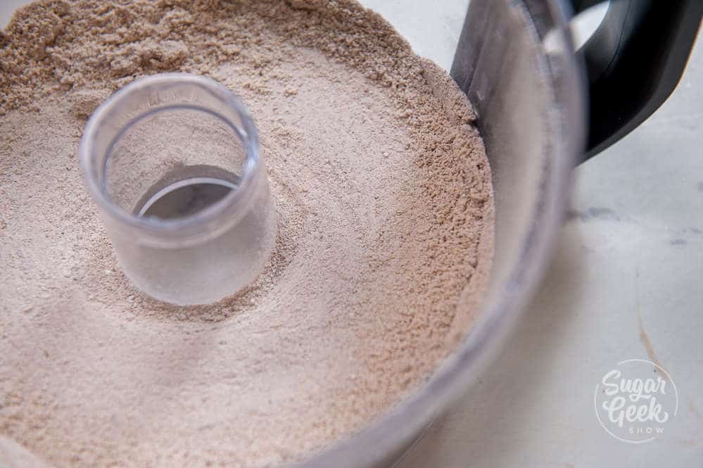closeup of almond flour and cocoa powder in food processor