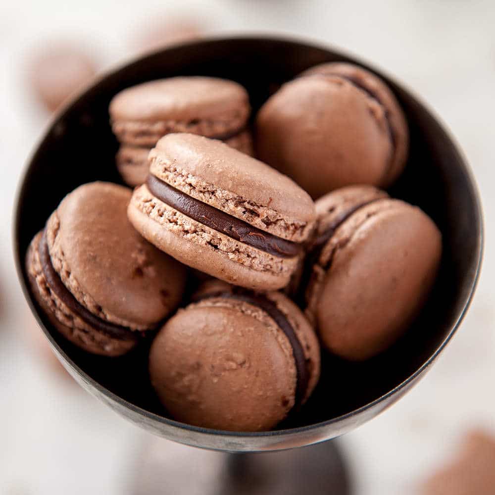 closeup of chocolate macarons in metal bowl