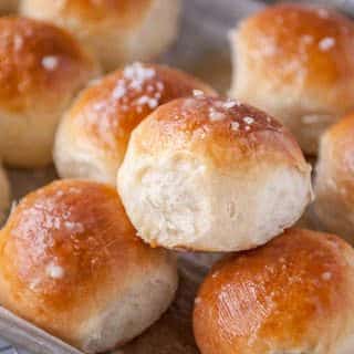 closeup of homemade dinner rolls with butter and sea salt