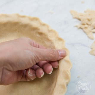 hand fluting edges of pie dough