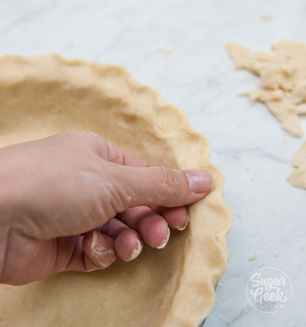 hand fluting edges of pie dough