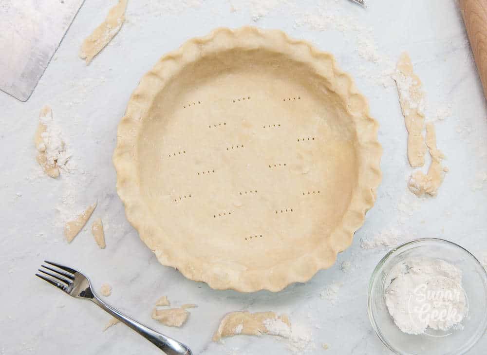 Pie dough docked with a fork and ready to freeze.