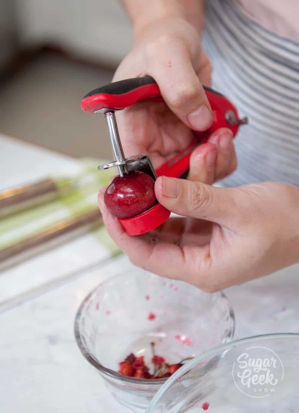 Using a cherry pitter to remove pits from cherries