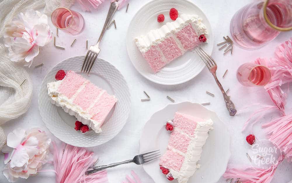 three slices of pink velvet cake on white plates shot overhead