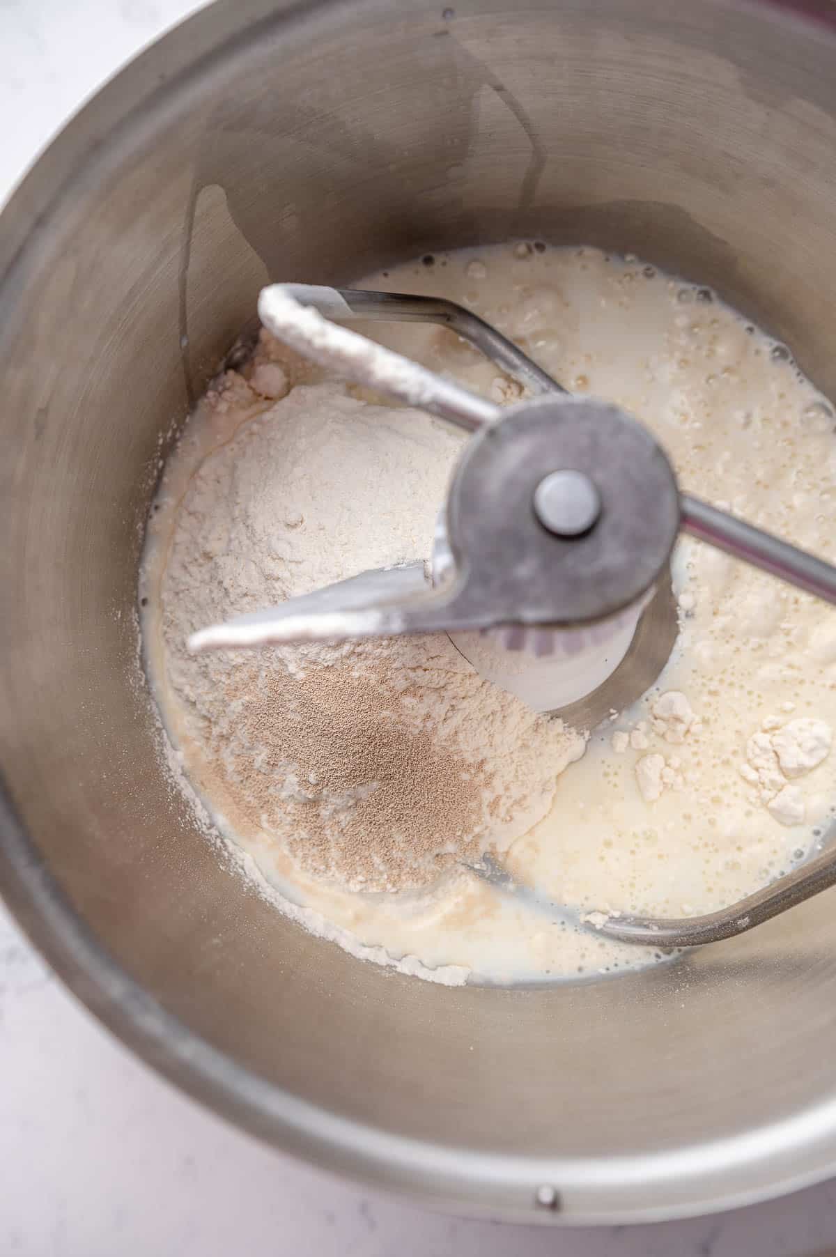 close up of cinnamon rolls in a mixing bowl shot from above