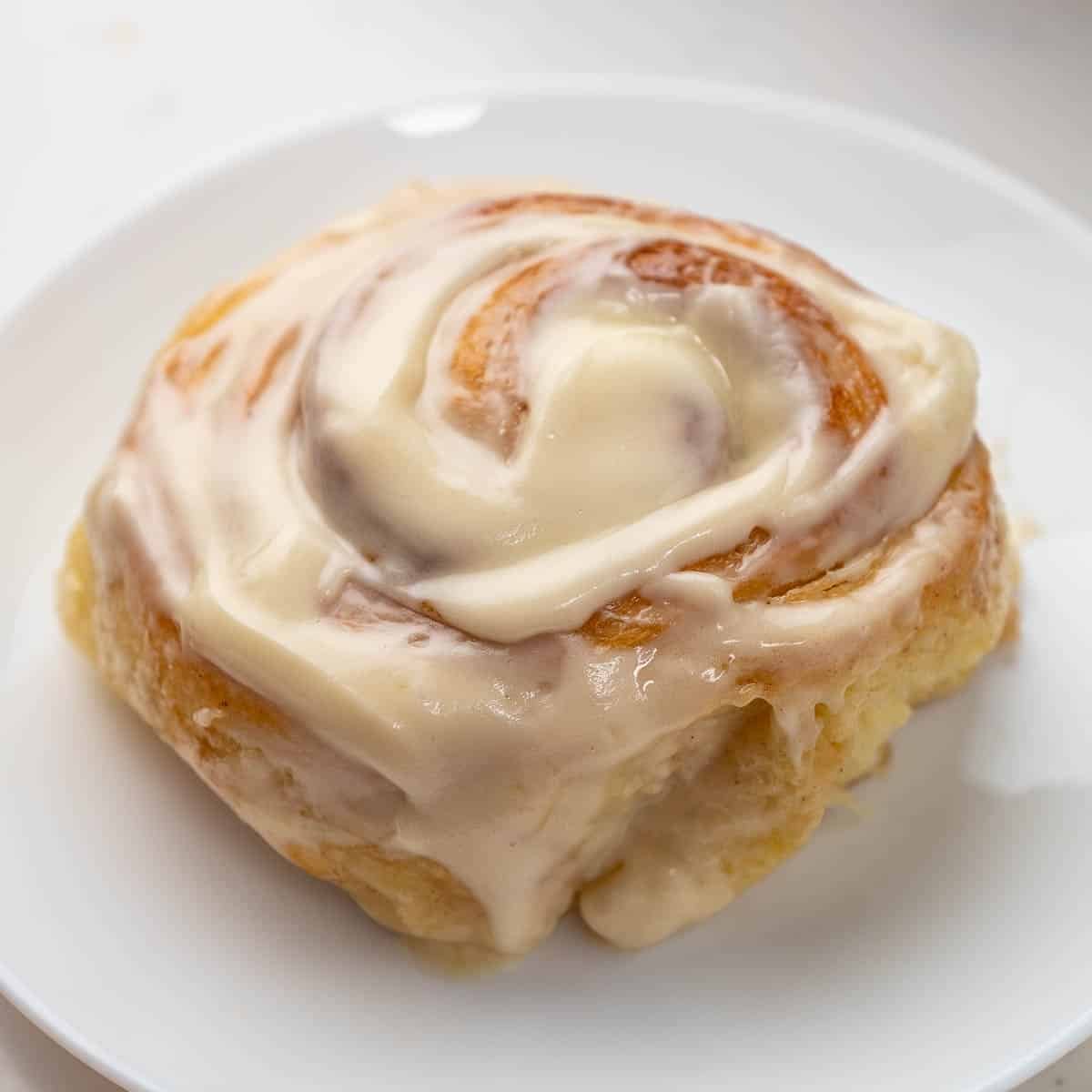 close up of cinnamon roll on a white plate