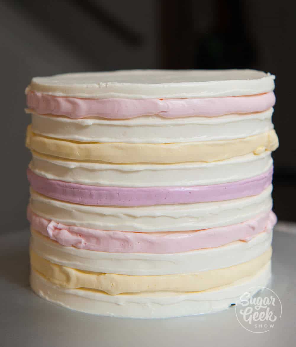 cake covered in buttercream with colorful strips