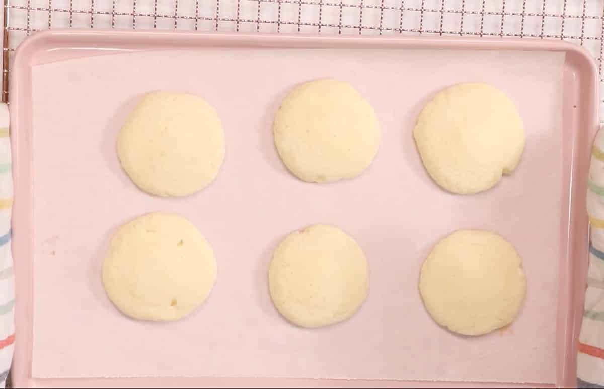 Baked Lofthouse cookies on a pink cookie sheet.