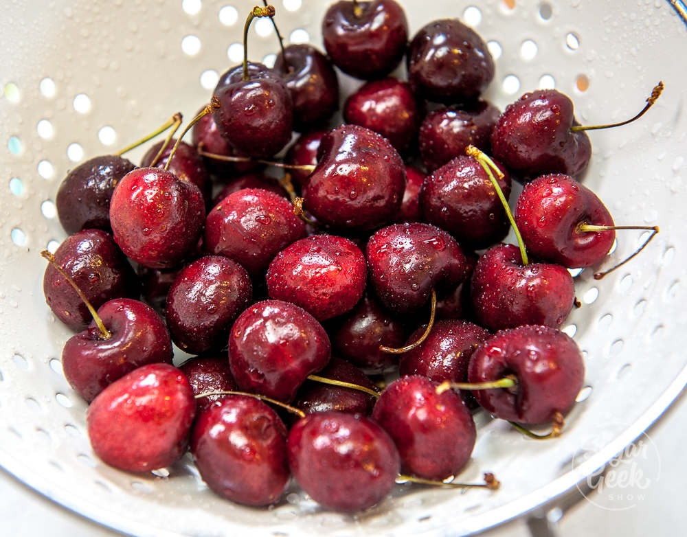 freshly washed cherries in a white colander 